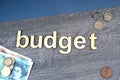 Budget 2023 on wood and blue background, British coins and notes Royalty Free Stock Photo