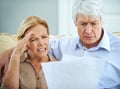 Budgeting burdens. an elderly couple looking frustrated while going over their paperwork together. Royalty Free Stock Photo