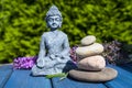 Budha figure with pyramide of stone of wooden background in the garden