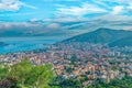 Budva city among mountains against moody dramatic sky over sea horizon