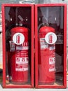 Budva, Montenegro - 08 august 2023: Two red fire extinguishers are in cabinets behind glass Royalty Free Stock Photo
