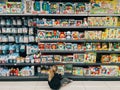 Budva, Montenegro - 01 december 2023: Little girl chooses a set of toys sitting on the floor in a supermarket