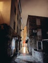 Budva, Montenegro - 25 december 2022: Narrow illuminated ancient street with luminous windows