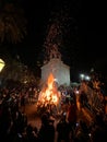 Budva, Montenegro - 25 december 2022: People stand around a large burning fire near the church Royalty Free Stock Photo