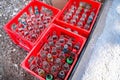 Budva, Montenegro, January 02, 2020: Some plastic crates with empty glass bottles from popular beverage on the ground, different k