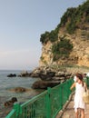 Budva / Montenegro - July 21, 2014: Girls in white summer dresses on fenced walkway below cliffs on Adriatic coasline