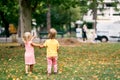 Budva, Montenegro - 01.08.22: Little girls walk in the park holding hands. Back view Royalty Free Stock Photo