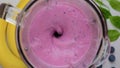 Bueberry, spinach and banana smoothie blended in blender. Cooking milkshake. Slow motion. Top view. Healthy drink