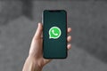 In this illustrative photo you can see the Whatsapp logo displayed on a smartphone screen with a defocused background of floor