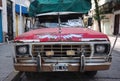 Front view of old Ford F-100 pickup truck with red hood, rust on hood and bumper Royalty Free Stock Photo