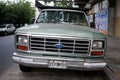 Front view of radiator grille, headlights, hood and chrome bumper with rust of Ford F-100 pickup truck
