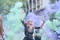 Women waving green and violet smoke flares in the air during 8M feminist strike