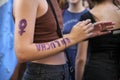 Argentina, 8M. Unrecognizable woman with the feminist symbol painted on her arm