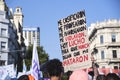 A woman holds up a poster with a message against violence against women