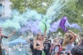 Women waving green and violet smoke flares in the air during 8M feminist strike