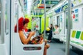 Buenos aires - august, 2018 curly girl sits in the subway and looks at the phone, Royalty Free Stock Photo