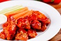 Buffalo chicken wings with blue cheese dip, carrots and celery sticks on white plate Royalty Free Stock Photo