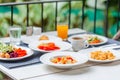 Buffet breakfast on terrace in outdoors restaurant at tropical hotel or resort. Brunch table with food and drinks, fried