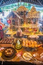 Buffet full of different kind of appetite tasty fresh made cakes and huge ginger house during christmas celebration