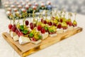 The buffet at the reception. Assortment of canapes on wooden board. Banquet service. catering food, snacks with cheese, jamon and