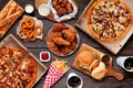 Buffet table scene of take out or delivery foods, above view over dark wood