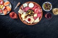 Buffet with wine and appetizers on a black background. Italian delicatessen