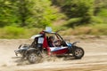 The buggy car is speeding through rough terrain in dusty clubs. The concept of extrieme offroad driving