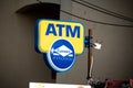 The blue and yellow logo of an ATM of the Euronet worldwide network of these machines in front of a local store