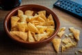 Bugles snack. Cone corn chips in bowl on wooden table Royalty Free Stock Photo