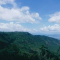 Buidings and towers on top of a green mountain with blue sky and white clouds at Tagaytay, Philippines