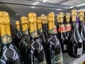 Close-up on bottles of Canard Duchene and Nicolas Feuillatte brand champagnes from the shelf of a supermarket in France