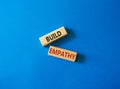 Build empathy symbol. Wooden blocks with words Build empathy. Beautiful blue background. Psychology and Build empathy concept. Royalty Free Stock Photo