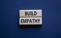 Build empathy symbol. Wooden blocks with words Build empathy. Beautiful deep blue background. Psychology and Build empathy concept Royalty Free Stock Photo