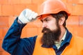 Build man. Confident builder in orange safety hat. Builder design. Brick wall background. Helmet for workers.