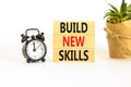 Build new skills symbol. Concept word Build new skills on beautiful wooden block. Black alarm clock. Beautiful white table white Royalty Free Stock Photo