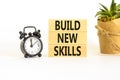 Build new skills symbol. Concept word Build new skills on beautiful wooden block. Black alarm clock. Beautiful white table white Royalty Free Stock Photo