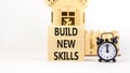 Build new skills symbol. Concept word Build new skills on beautiful wooden block. Black alarm clock. Beautiful white table white Royalty Free Stock Photo