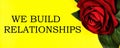 We build relationships - text inscription on the background of a red rose.