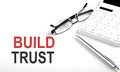 BUILD TRUST Concept. Calculator,pen and glasses on white background Royalty Free Stock Photo