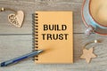 BUILD TRUST - inscription on a notebook and cup with coffee