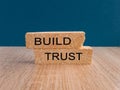 Build trust symbol. Concept words Build trust on brick blocks on a beautiful wooden table, dark blue background Royalty Free Stock Photo