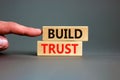 Build trust symbol. Concept words Build trust on wooden blocks on a beautiful grey table grey background. Businessman hand. Royalty Free Stock Photo