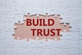 Build trust symbol. White puzzle with words Build trust. Beautiful pink background. Business and Build trust concept. Copy space