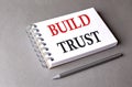 BUILD TRUST word on notebook on grey background
