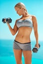 Build your body one workout at a time. a beautiful young woman working out with dumbbells outside. Royalty Free Stock Photo