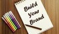 Build Your Brand. your future target searching, a marker, pen, three colored pencils and a notebook for writing Royalty Free Stock Photo