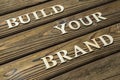 Build your brand text is composed of letters on a wooden background. Royalty Free Stock Photo