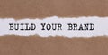 Build your brand written under torn paper on white background Royalty Free Stock Photo