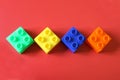 Buildable colored plastic blocks to play, build and organize on a red background as a concept of inclusion, diversity and pluralit Royalty Free Stock Photo