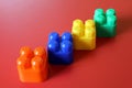 Buildable colored plastic blocks to play, build and organize on a red background as a concept of inclusion, diversity and pluralit Royalty Free Stock Photo